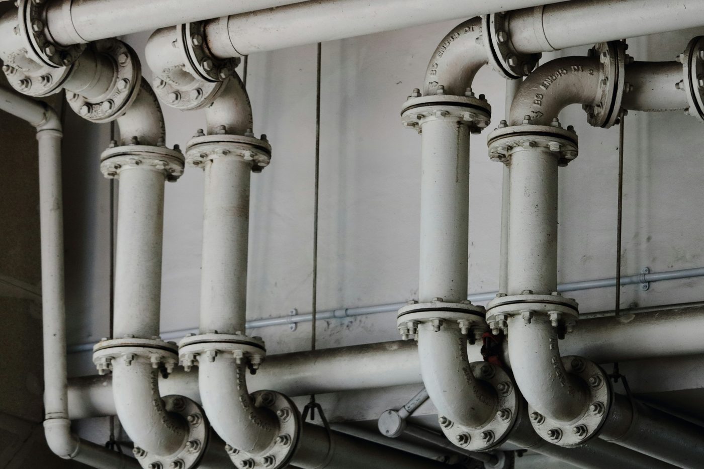 Rows of large flanged pipes in a commercial building